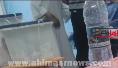 زجاجات المياه المعدنية تحمل صورة رمز مرشح بدائرة البندر في قنا